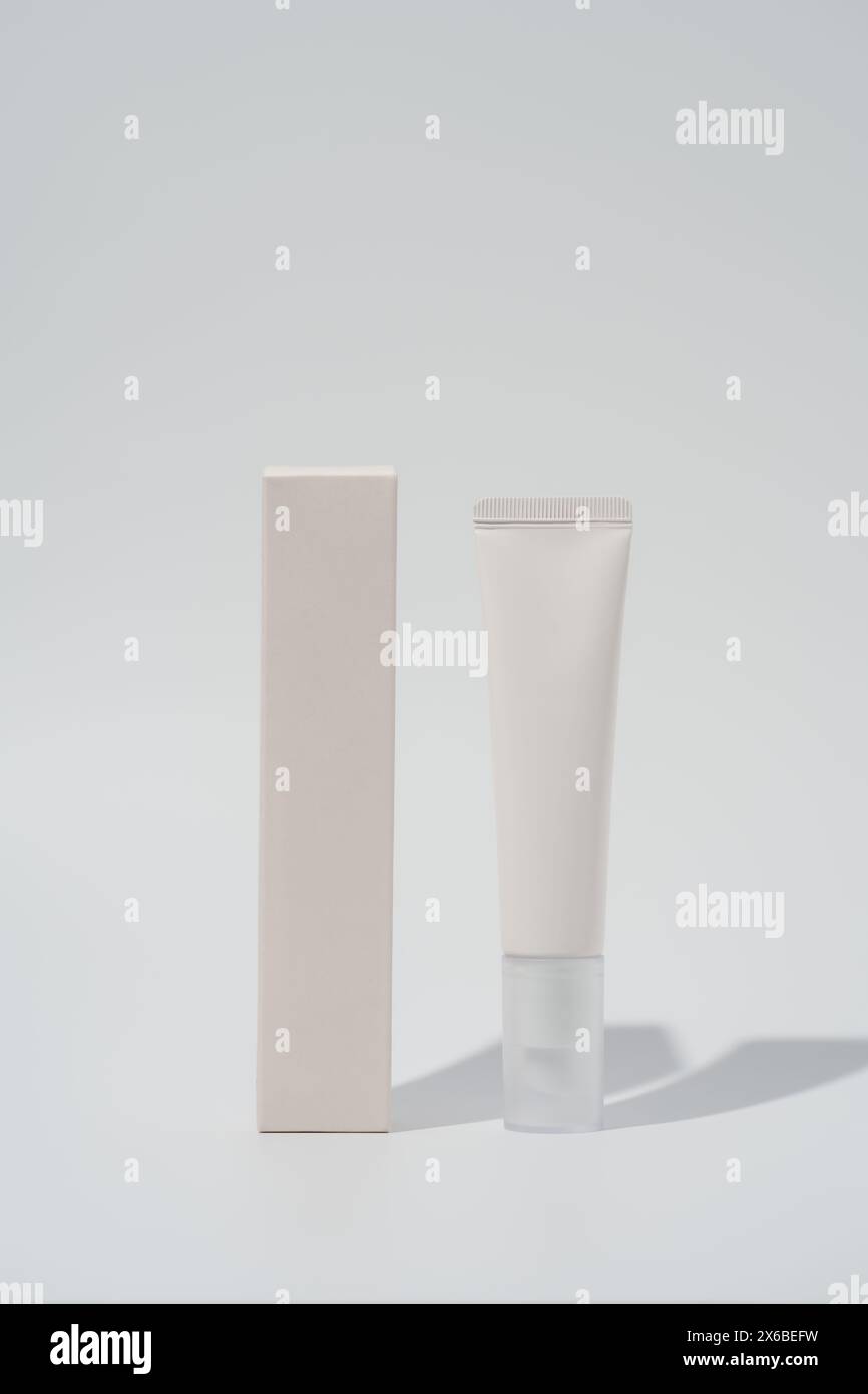 Mockup Creme Tube und Box auf leerem Hintergrund. Minimalistische Produktpräsentation Stockfoto