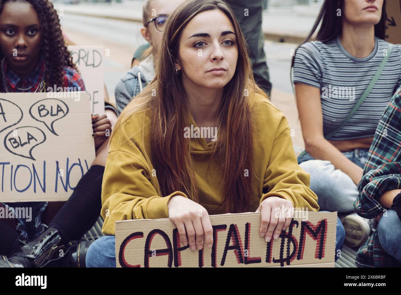 Vertretung junger Aktivisten, die an einem Anti-Kapitalismus-Protest teilnahmen, Zeichen halten und Entschlossenheit zeigen, Straßendemonstration für Sozia Stockfoto