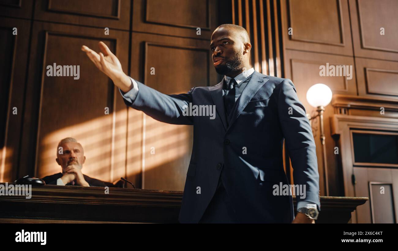 Court of Justice and Law Trial: Erfolgreicher männlicher Public Defender präsentiert den Fall und hält leidenschaftliche Rede vor dem Richter, Jury. Rechtsanwalt, der den Mandanten schützt, indem er nicht schuldig argumentiert Stockfoto