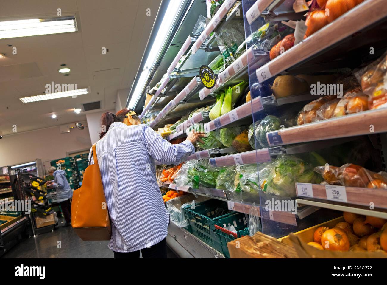 Rückansicht Person Frau, die Lebensmittel Gemüse kauft, Blick auf Blattgemüse in vegetarischen Regalen in der Lebensmittelhalle des M&S Supermarktes UK KATHY DEWITT Stockfoto