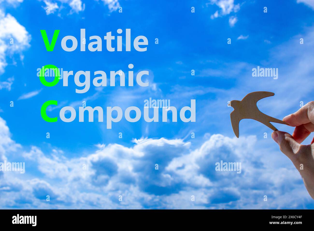 VOC-Symbol für flüchtige organische Verbindungen. Konzeptworte VOC flüchtige organische Verbindung auf wunderschönem blauem Wolkenhintergrund. Holzvogel. Business VOC V Stockfoto