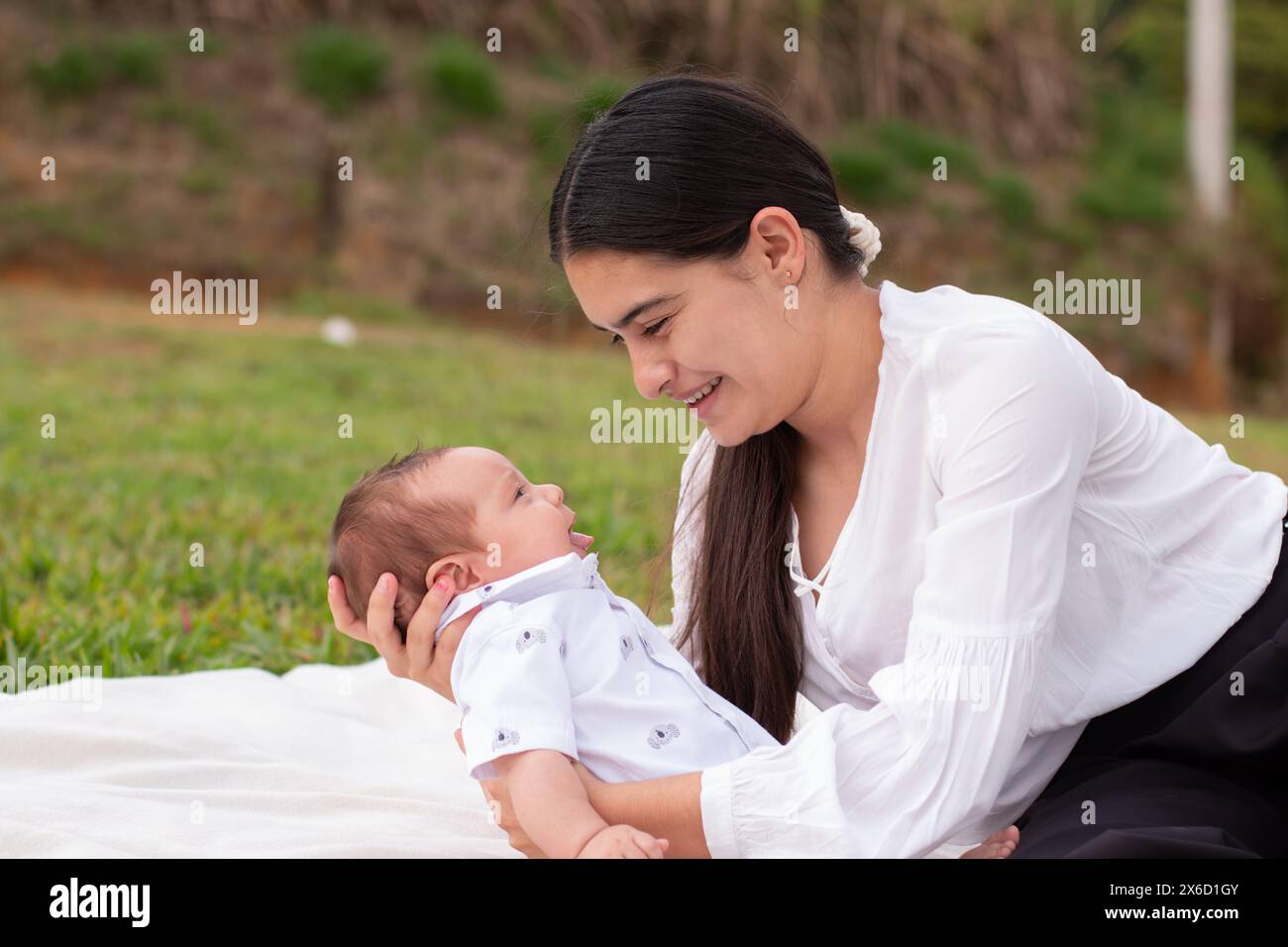 Lebensstil: Eine Mutter, die sich mit ihrem Baby auf einer Wiese sonnt Stockfoto