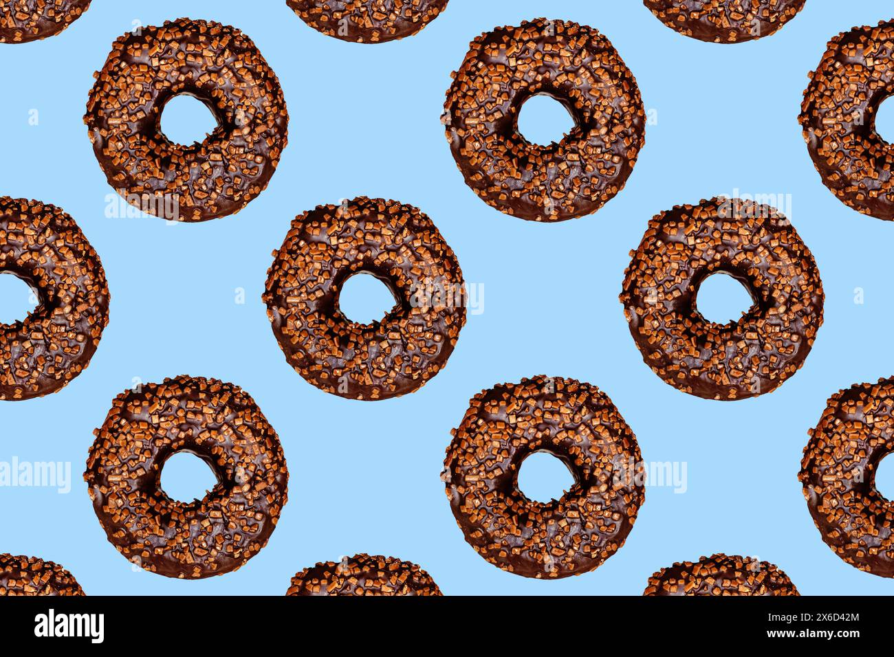 Kreatives Muster von Schokoladendonuts mit Löchern auf blauem Hintergrund. Stockfoto