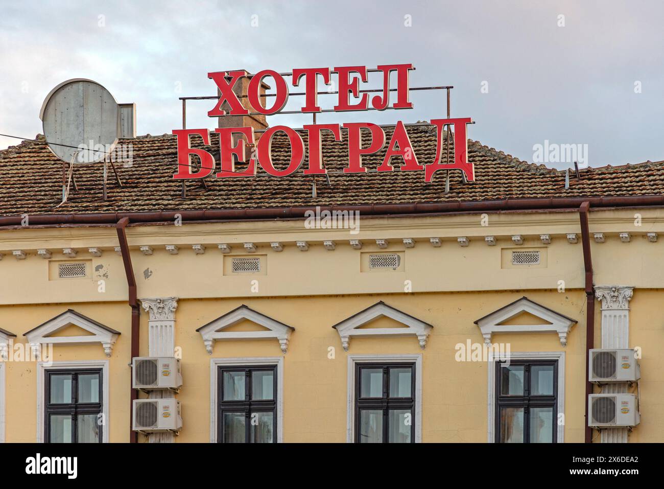 Negotin, Serbien - 14. März 2024: Kyrillisches Schild mit roten Buchstaben Hotel Beograd am oberen Ende des alten Gebäudes am Frühlingnachmittag. Stockfoto