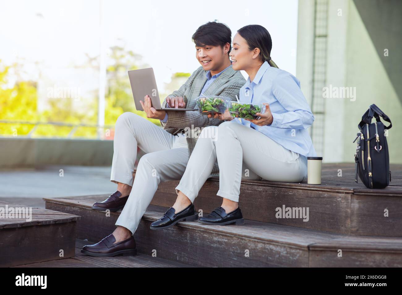 Junge Geschäftsleute, die gemeinsam an einem Laptop im Freien arbeiten Stockfoto