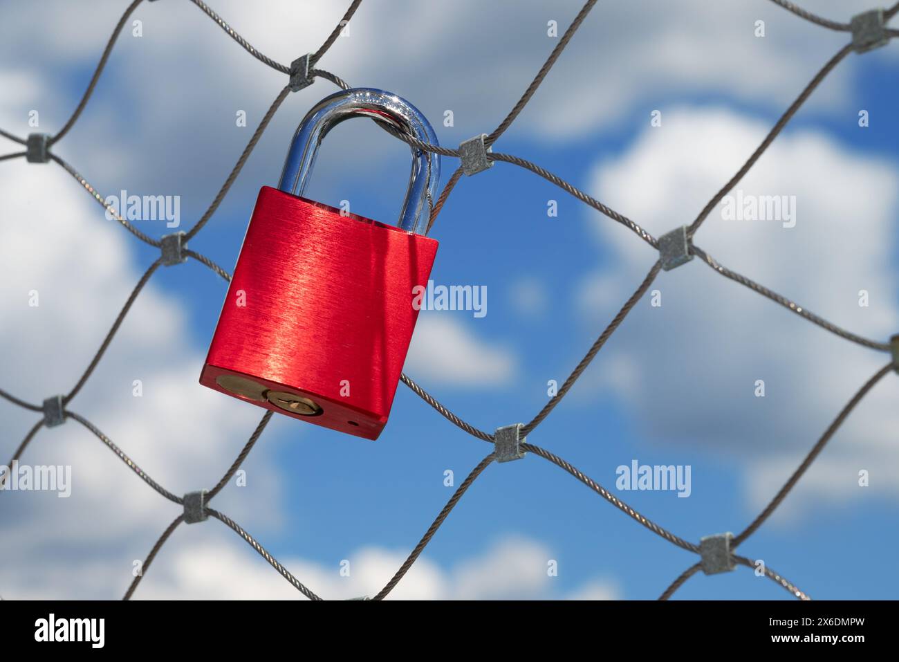 Ein einziges rotes Liebesschloss hängt an einem Brückengeländer Stockfoto