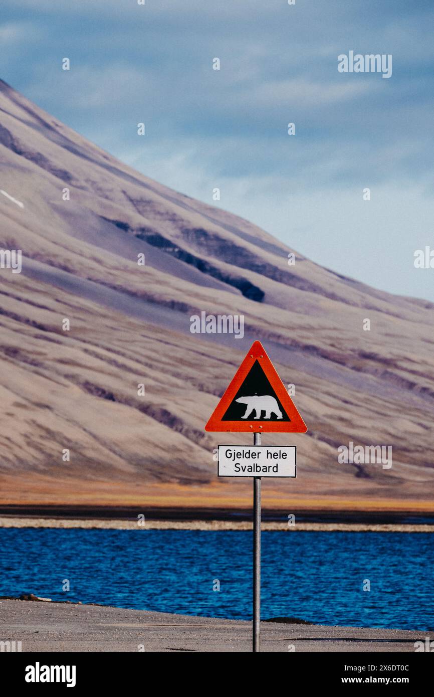 Eisbärenwarnschild vor bergiger Kulisse in Longyearbyen, Svalbard Stockfoto