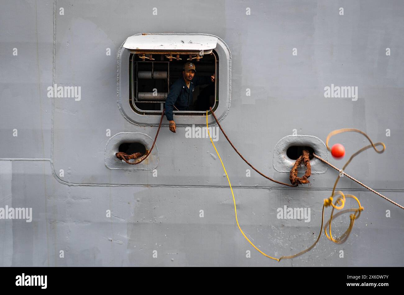 12. Mai 2024 - Bandar Lampung, Indonesien - Ein Matrose an Bord des amphibischen Transportdocks USS Somerset (LPD 25) startet eine Heaving-Linie, als das Schiff im Hafen Panjang in Bandar Lampung, Indonesien ankommt, um 2024 am 12. Mai 2024 kooperieren zu können. In diesem Jahr findet die 30. Wiederholung von CARAT statt, einer multinationalen Übungsreihe, die die Fähigkeit der US-amerikanischen und Partnerflotten verbessern soll, gemeinsam auf traditionelle und nicht traditionelle Herausforderungen im Bereich der maritimen Sicherheit in der indopazifischen Region zu reagieren. (Kreditbild: © James Finney/USA Navy/ZUMA Press Wi Stockfoto