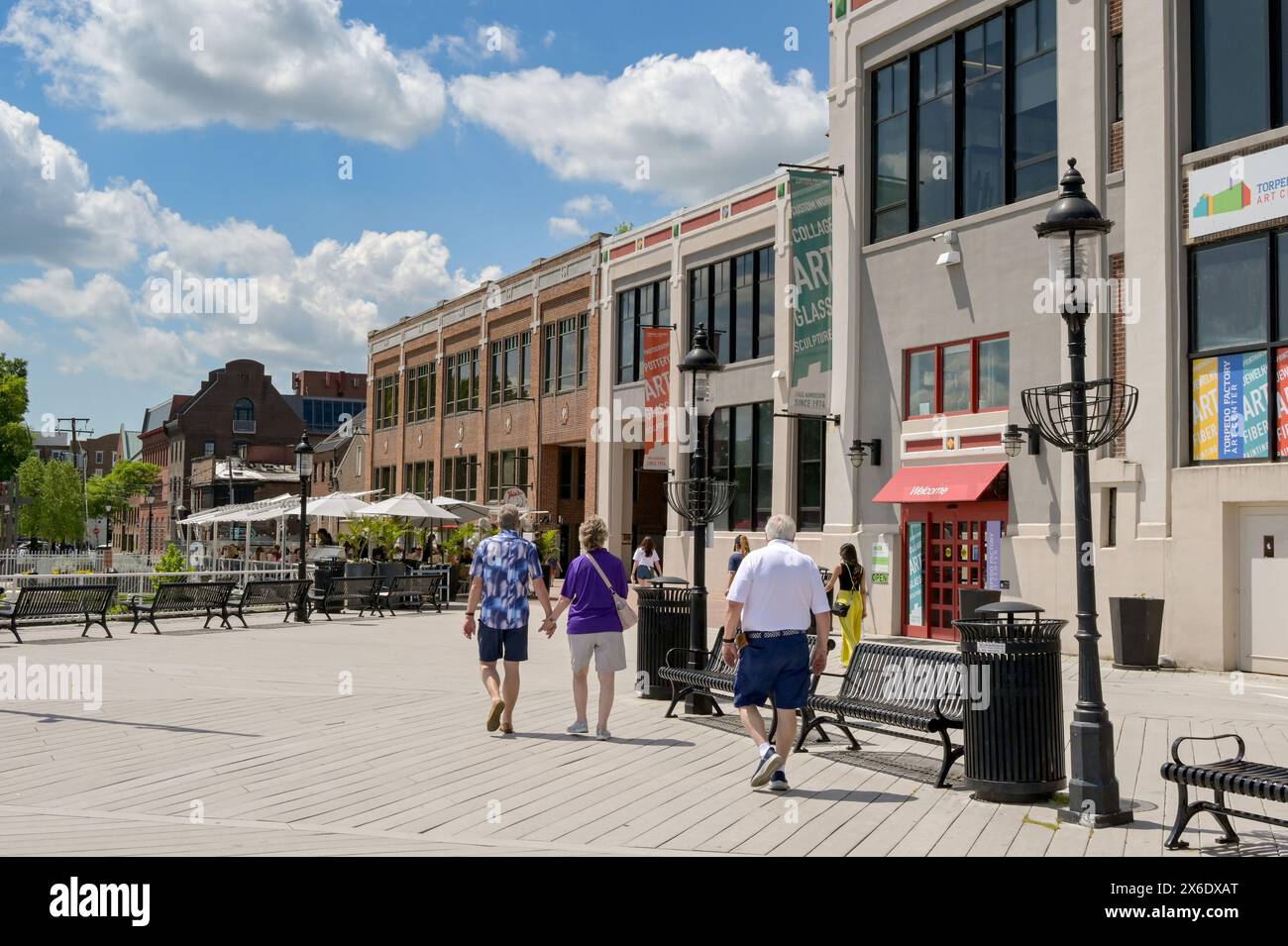 Alexandria, Virginia, USA - 1. Mai 2024: Menschen gehen entlang der Promenade am Ufer der Stadt vorbei an renovierten alten Gebäuden Stockfoto