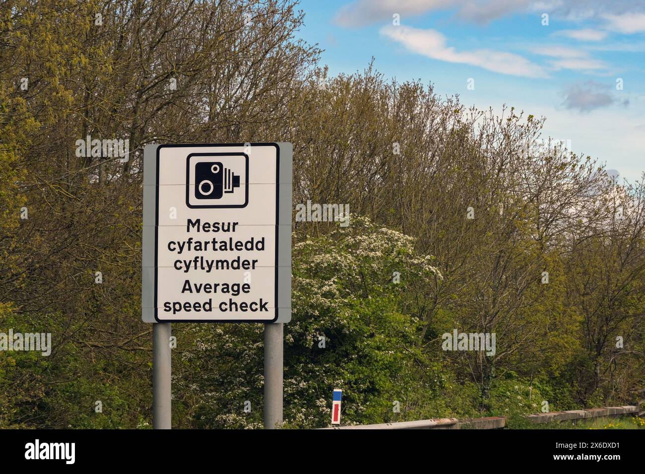 Radarkamerasymbol auf einem zweisprachigen Schild, das den Beginn einer durchschnittlichen Geschwindigkeitskontrolle auf einer Autobahn in Wales kennzeichnet Stockfoto