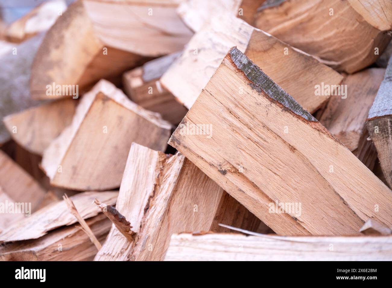 Nahaufnahme von frisch gehacktem Brennholz auf einem rustikalen Stapel, mit verschiedenen natürlichen Texturen und Holztönen Stockfoto