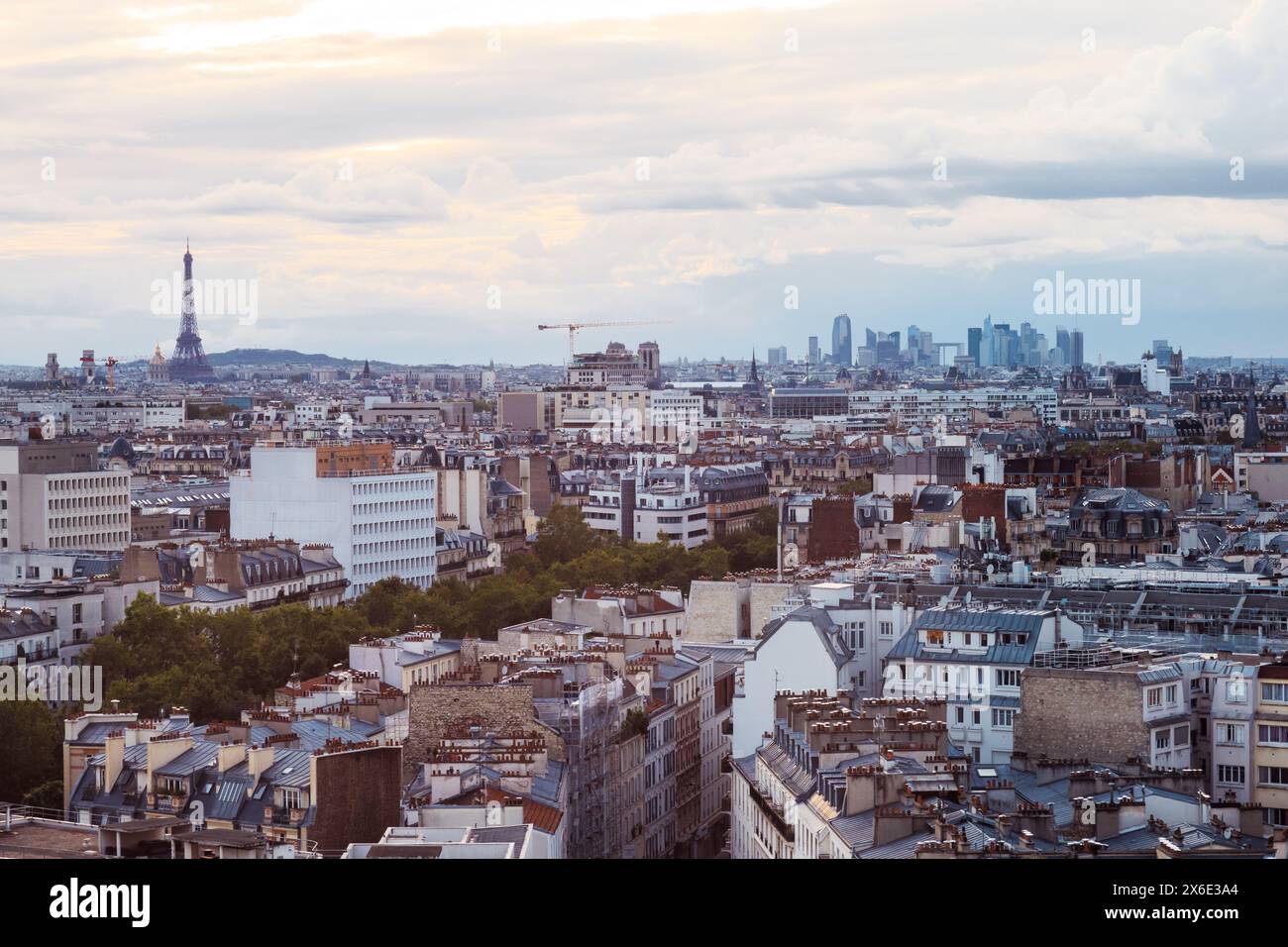 Pariser Stadtlandschaft mit Eiffelturm und Verteidigungsviertel bei Sonnenuntergang an einem bewölkten Tag Stockfoto