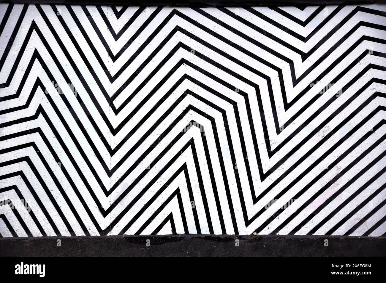 Geometrische abstrakte, wiederkehrende schwarze, dicke Linien, die auf einer weißen Oberfläche gezeichnet werden Stockfoto