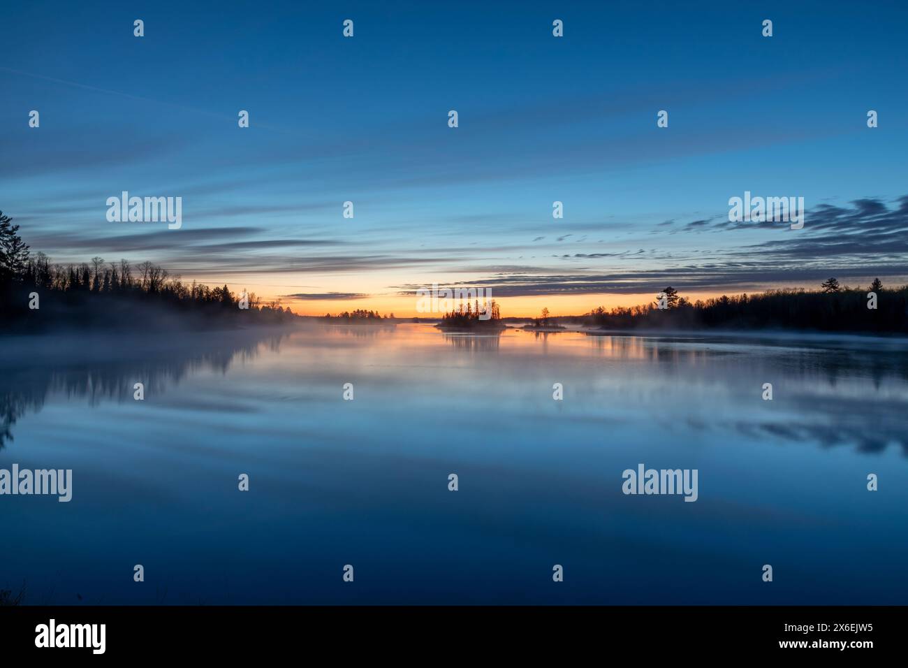 Die Sonne geht im Norden von Minnesota nahe Duluth über einer wunderschönen Seeszene auf, während Dampf aus dem ruhigen Wasser steigt Stockfoto