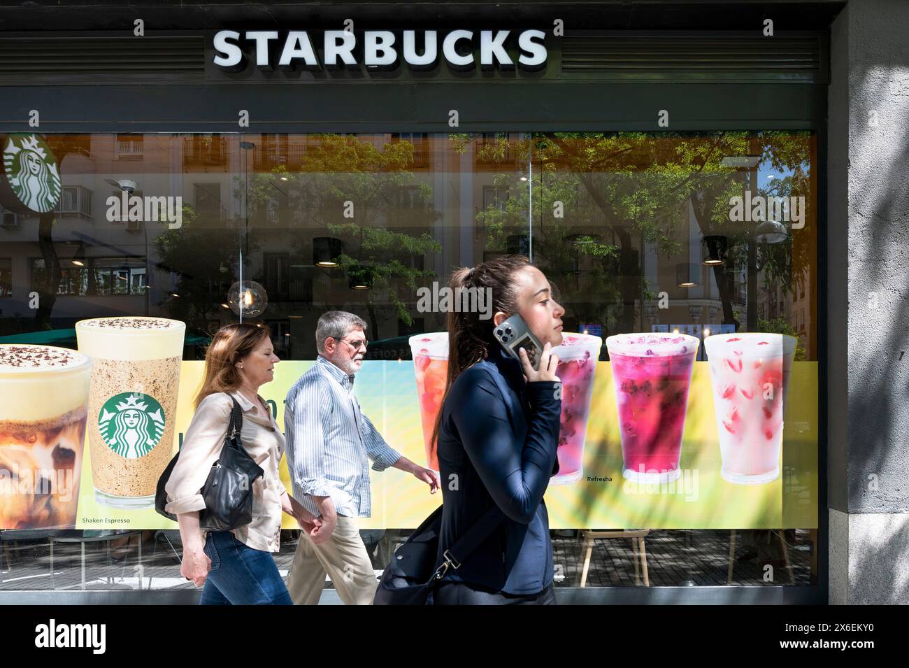 Fußgänger kommen an der amerikanischen multinationalen Kette Starbucks Coffee Store in Spanien vorbei. Stockfoto