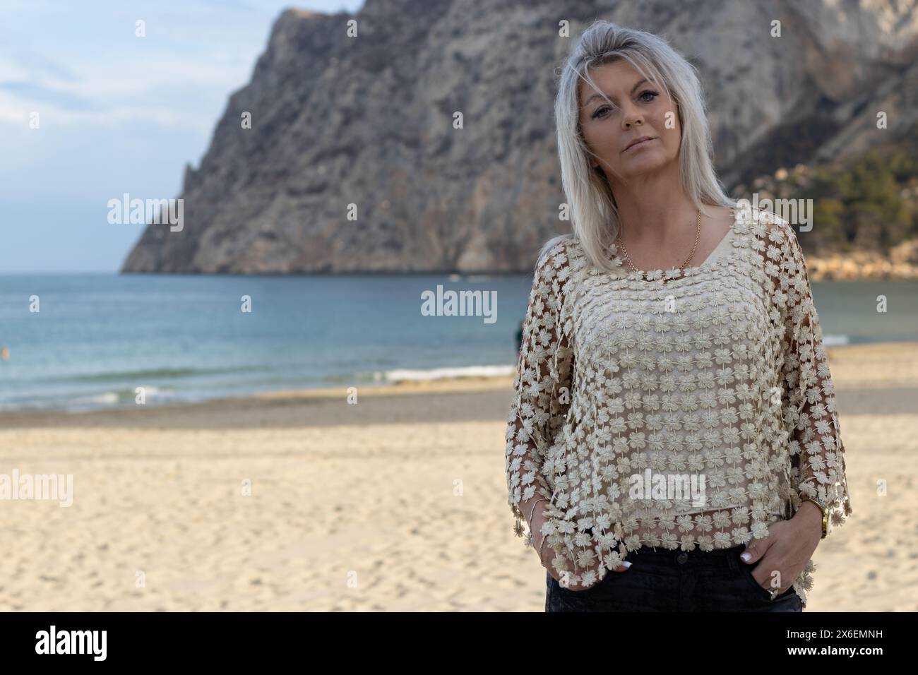Dieses Porträt fängt die heitere Schönheit einer Frau an den sonnenverwöhnten Stränden von Calpe, Spanien, ein. Stockfoto