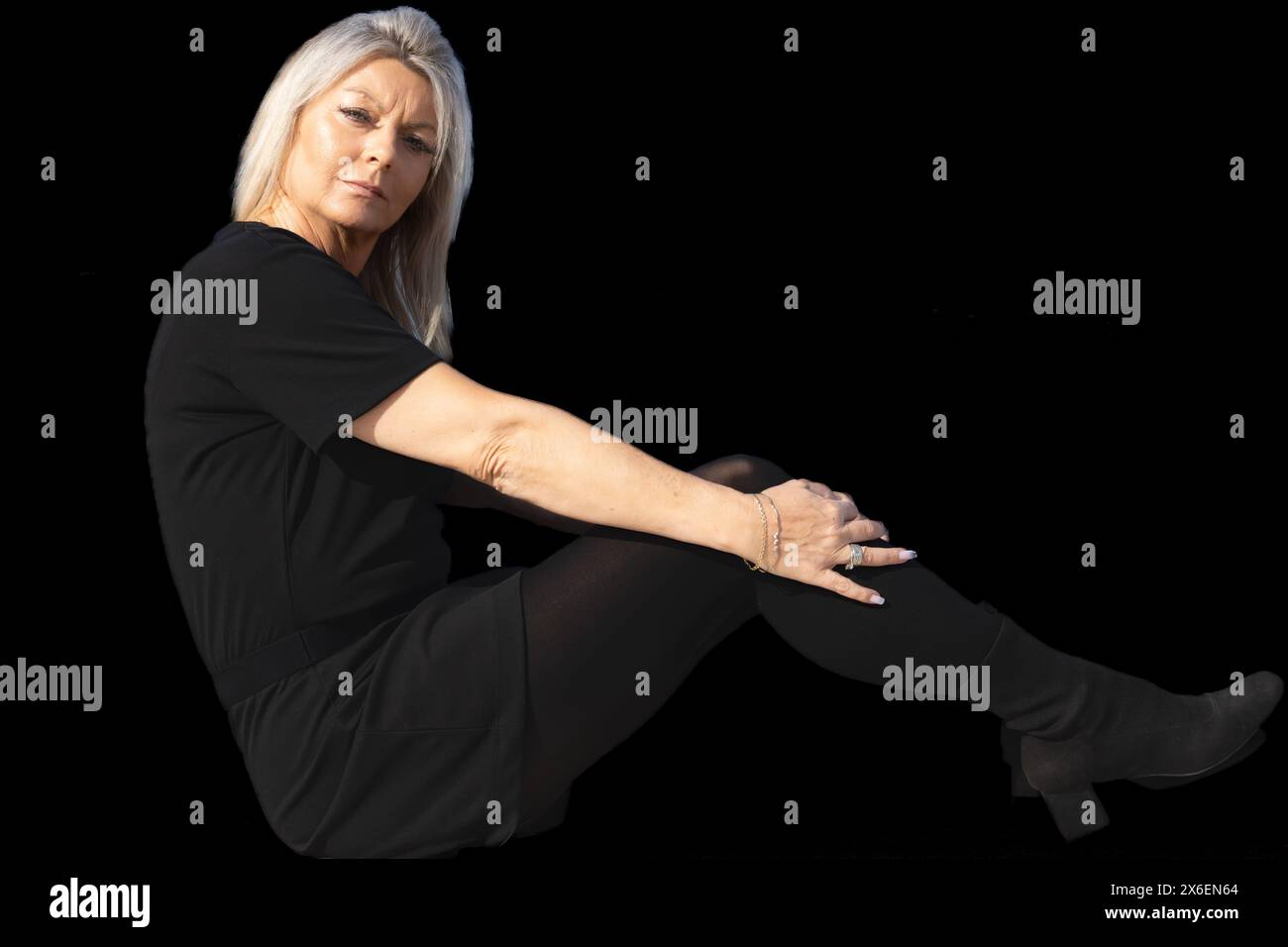 Dieses beeindruckende Porträt zeigt die würdevolle Schönheit einer 50-jährigen Frau vor tiefschwarzem Hintergrund. Stockfoto