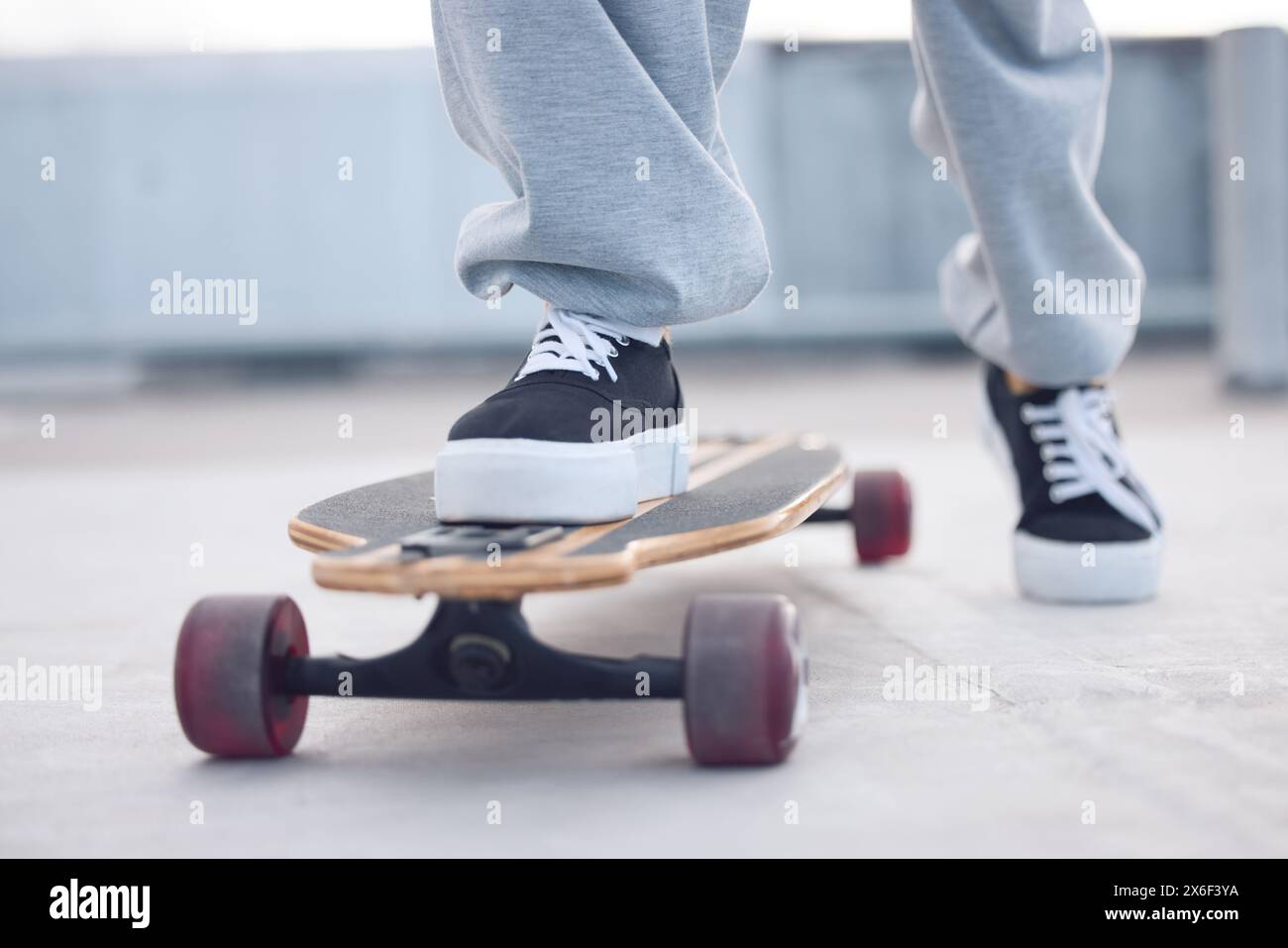 Füße, Beine und Sneaker im Freien auf Skateboard für Balance mit Streetwear, Style-Inspiration und Betonboden. Schuhe von Person, Mode und Stockfoto