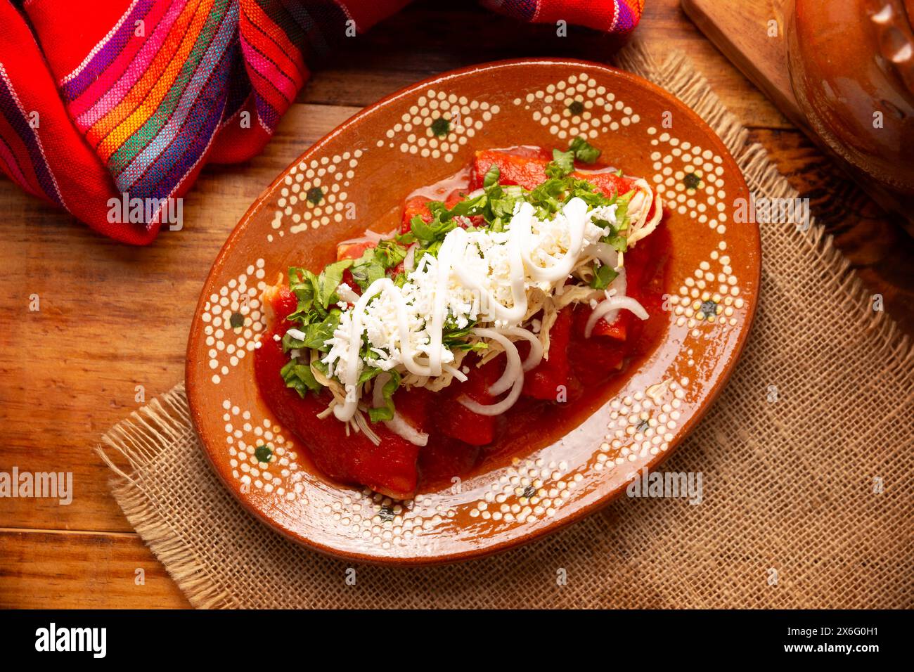 Entomatadas. Auch bekannt als Enjitomatadas, ein typisches Gericht der mexikanischen Küche, zubereitet mit Maistortilla, Tomatensauce und gefüllt mit geriebenem Hühnchen Stockfoto