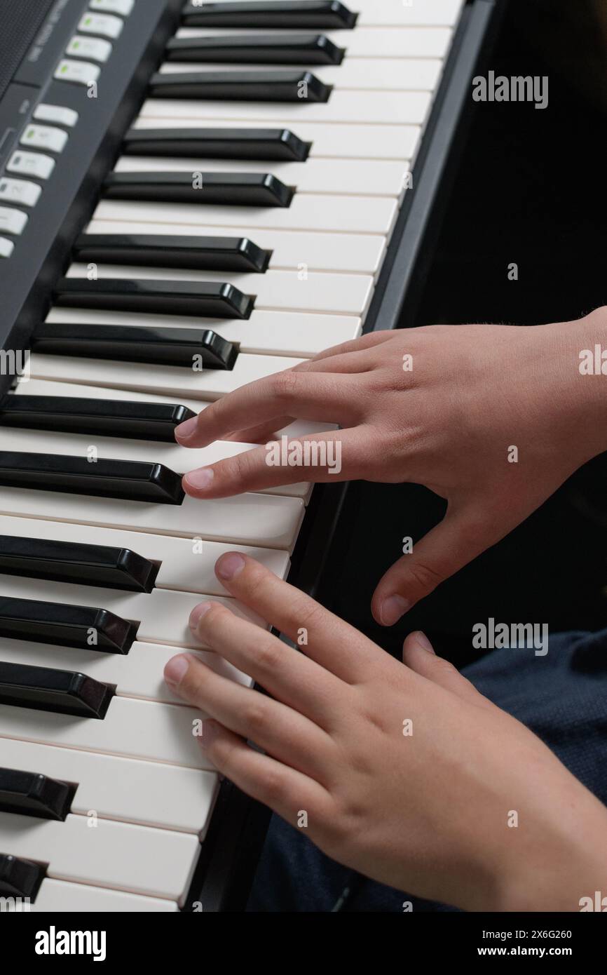 Klavierunterricht. Zwei Hände spielen Akkorde und Waagen üben sich aus. Nahaufnahme der Synthesizer-Tastatur. Stockfoto