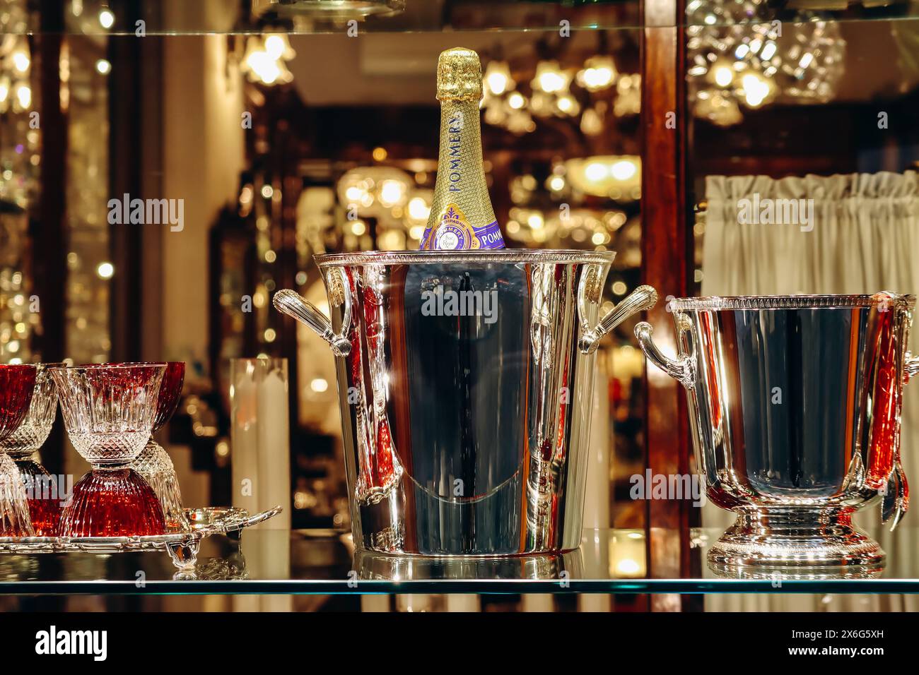 Florenz, Italien - 29. Dezember 2023: Eine Flasche Pommery Champagner in einem Eiskübel und elegante Kristallgläser Stockfoto