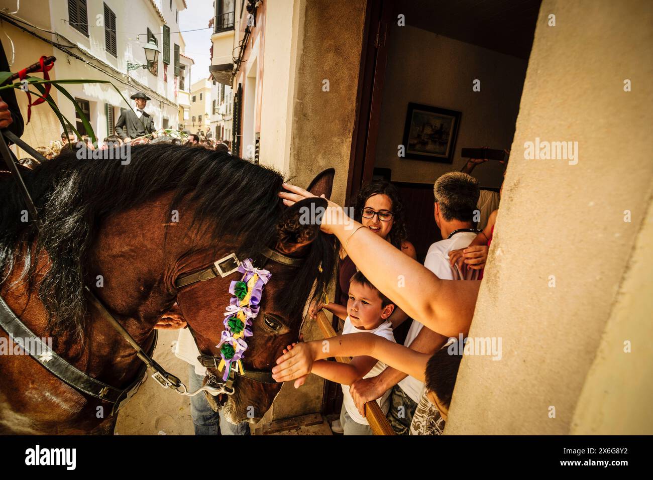 Reiter betreten die Häuser mit dem Pferd, Caragol de Santa Clara, Sant Joan Festival. Ciutadella. Menorca, Balearen, Spanien Stockfoto