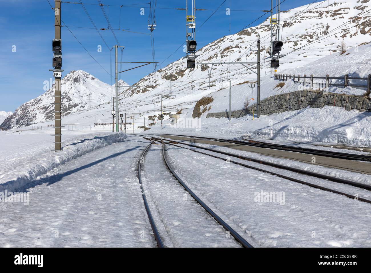 Bahnhof am Berninapass in der Schweiz. Bahnschalter und Gleise, die aus dem Schnee erscheinen. Niemand drinnen Stockfoto