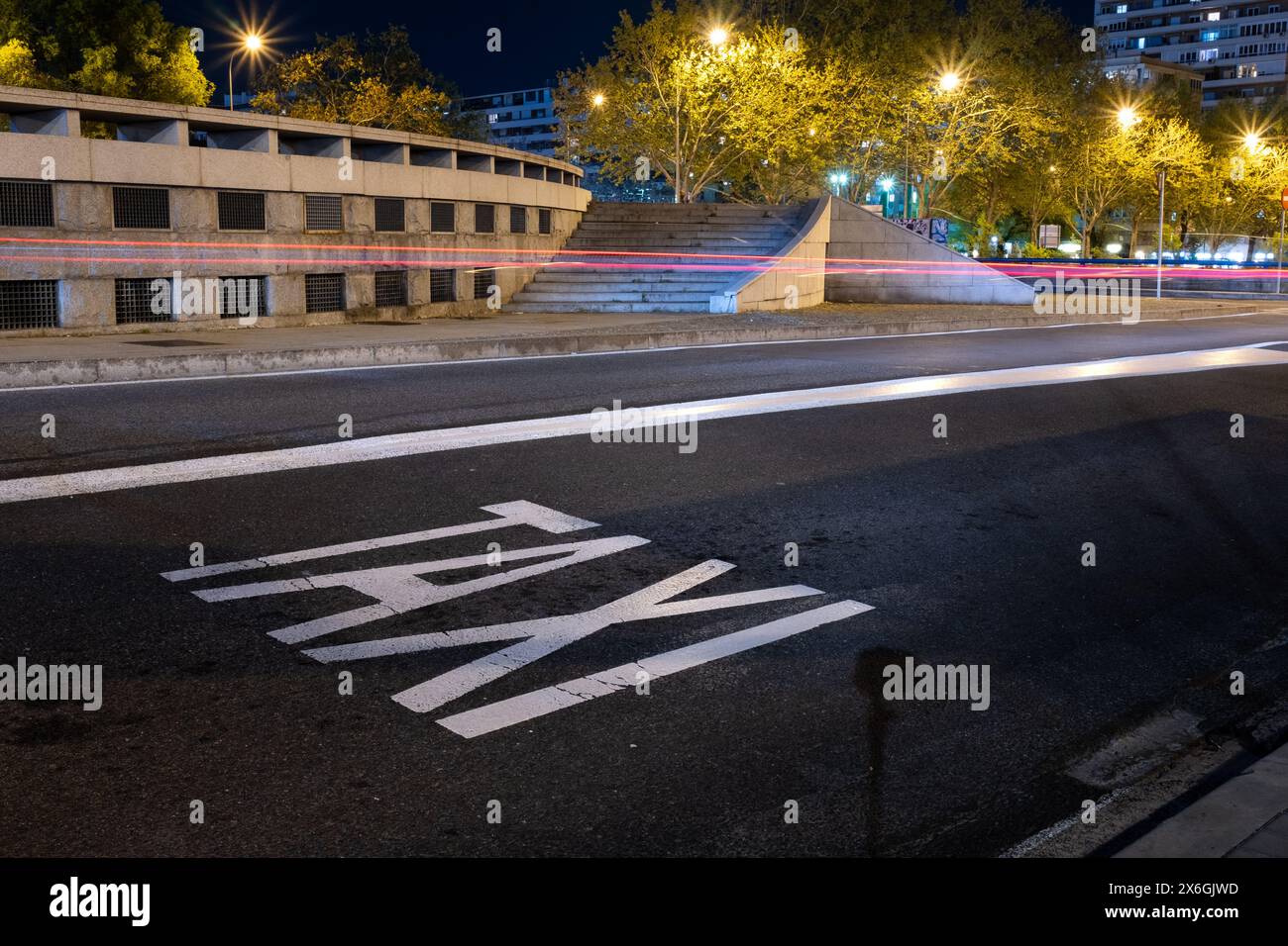 Horizontales Taxischild in der Stadt Madrid. Er ist mit reflektierender Farbe auf den Asphalt gemalt. Die Lichtstreifen eines vorbeifahrenden Autos sind zu sehen, wi Stockfoto