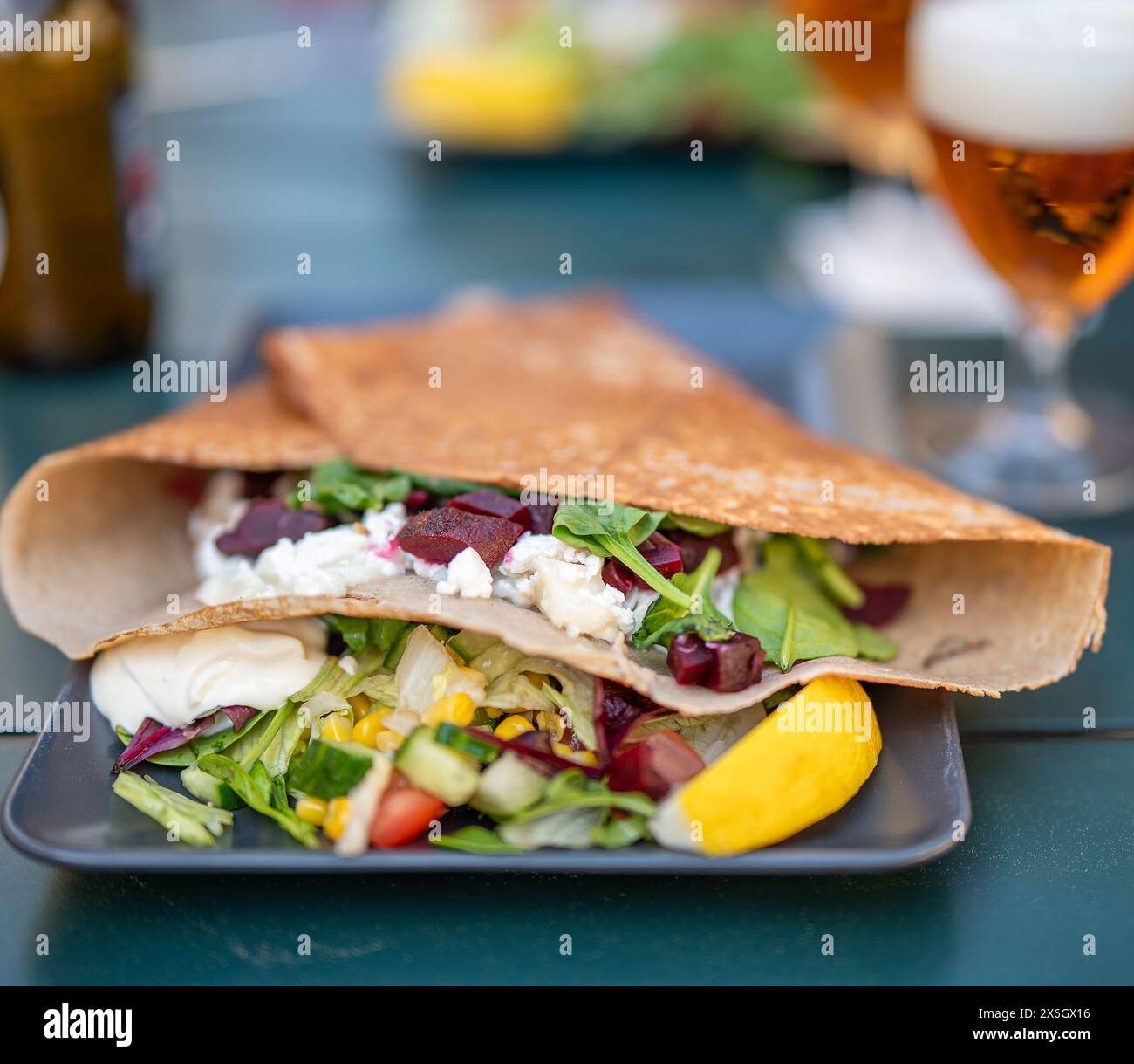 Galette mit Chèvre und Rote Bete, Gurke, Salat, Mais und Tomaten in einem Café im Freien in Norrköping, Schweden Stockfoto