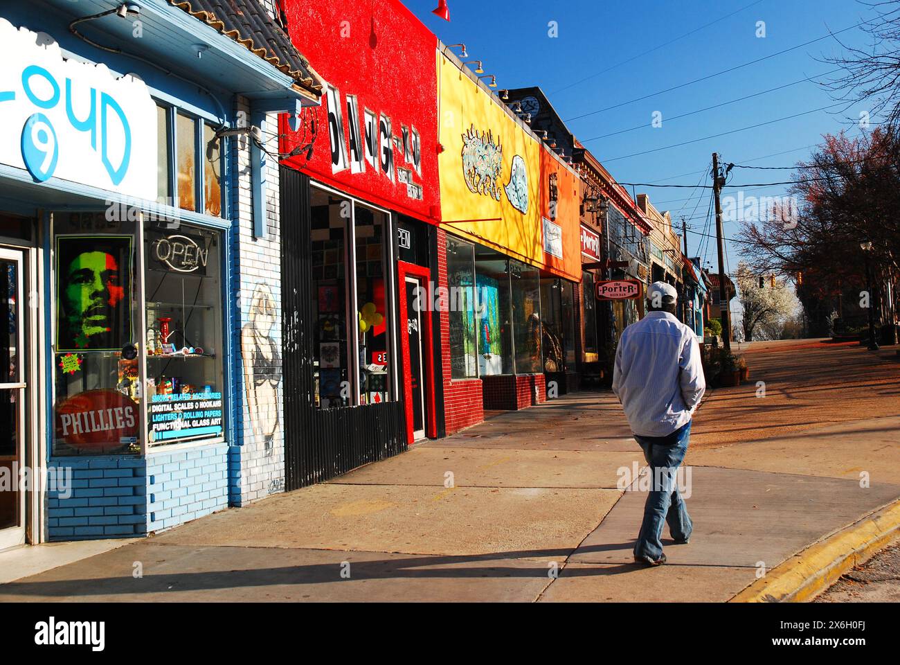 Ein erwachsener Mann spaziert vorbei an den vielseitigen Geschäften und alternativen funkigen Geschäften des Little Five Points Einkaufsviertels in Atlanta Stockfoto