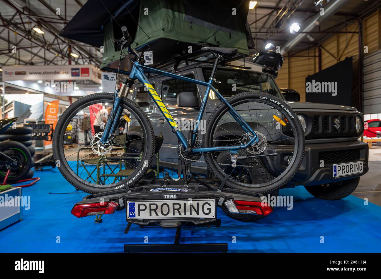 Riga, Lettland, 19. April 2024: Campingzelt auf dem Dach und Fahrradhalterung für Transport, Tourismusausstellung Stockfoto