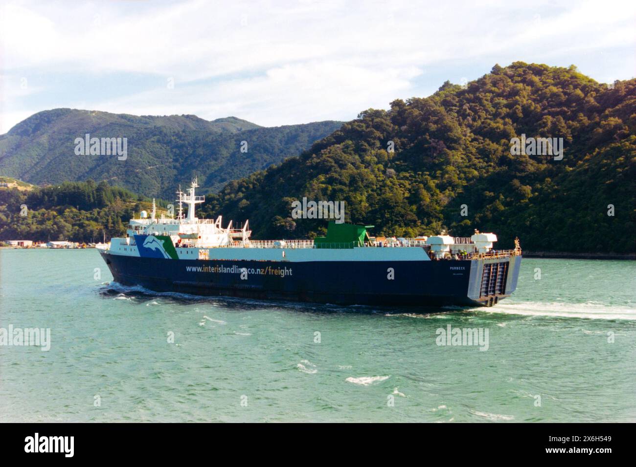 Das Frachtschiff Purbeck der InterIsland Line fährt von Picton über die Cook Straight nach Wellington in Neuseeland. Das Schiff wurde 1978 für Truckline Ferries France in Betrieb genommen und diente bis 2003 als Tranz Rail für den Fährdienst NZ zunächst Cherbourg nach Poole und später auch verschiedene andere britische und französische Häfen mit verschiedenen Betreibern. Die Charter wurde 2005 fertiggestellt, wobei das Schiff nach Venezuela verkauft wurde, in MV Maria Rosario umbenannt wurde und von Puerto La Cruz aus bedient wurde, in dem es 2018 aufgrund mangelnder Instandhaltung teilweise versunken sein soll Stockfoto