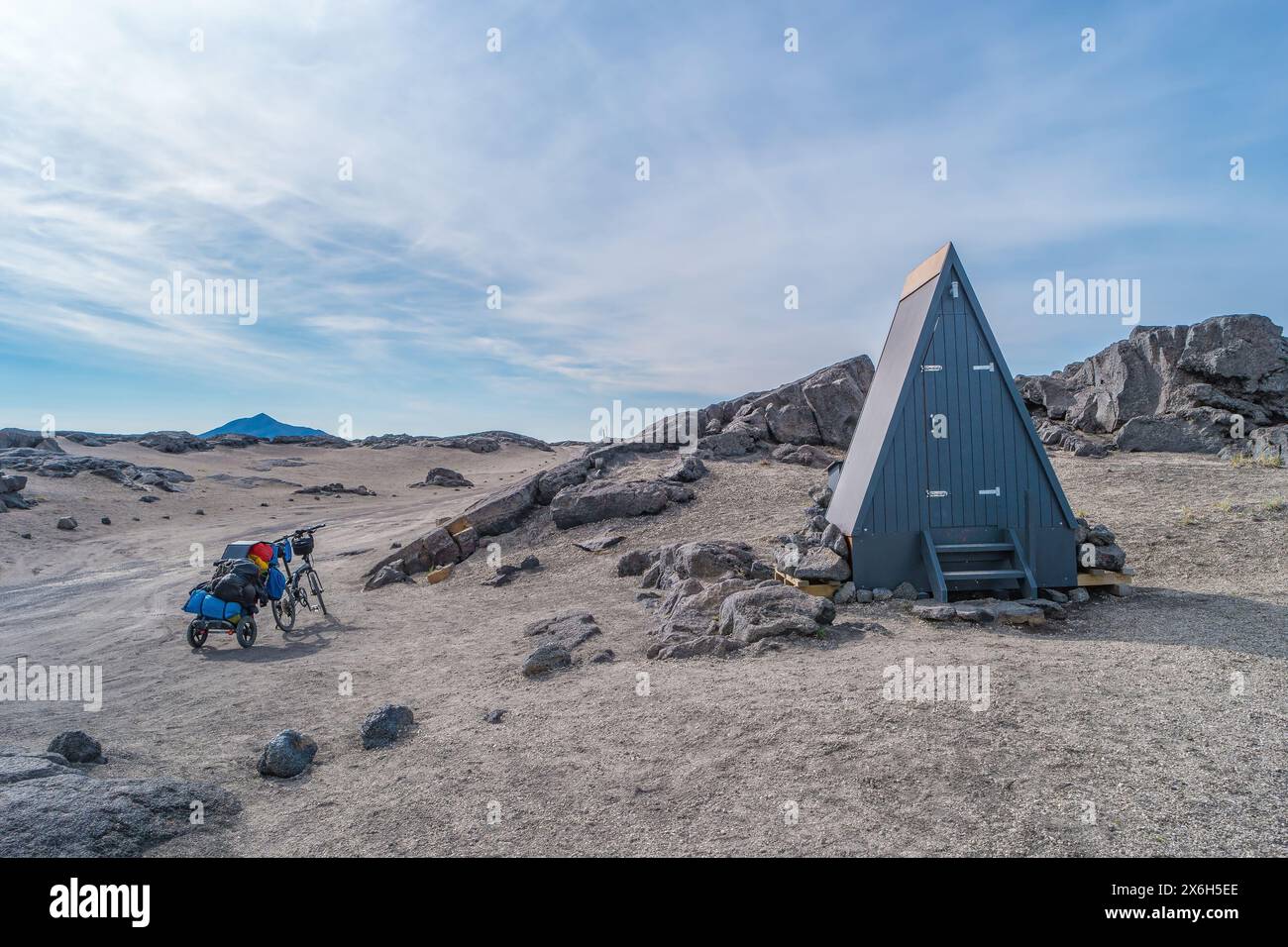 Moderne öffentliche Toilette im Freien und ein Tourenrad mitten im Nirgendwo, in der tödlichsten Vulkanwüste in den Highlands nahe Askja, mit Steinen und Ro Stockfoto