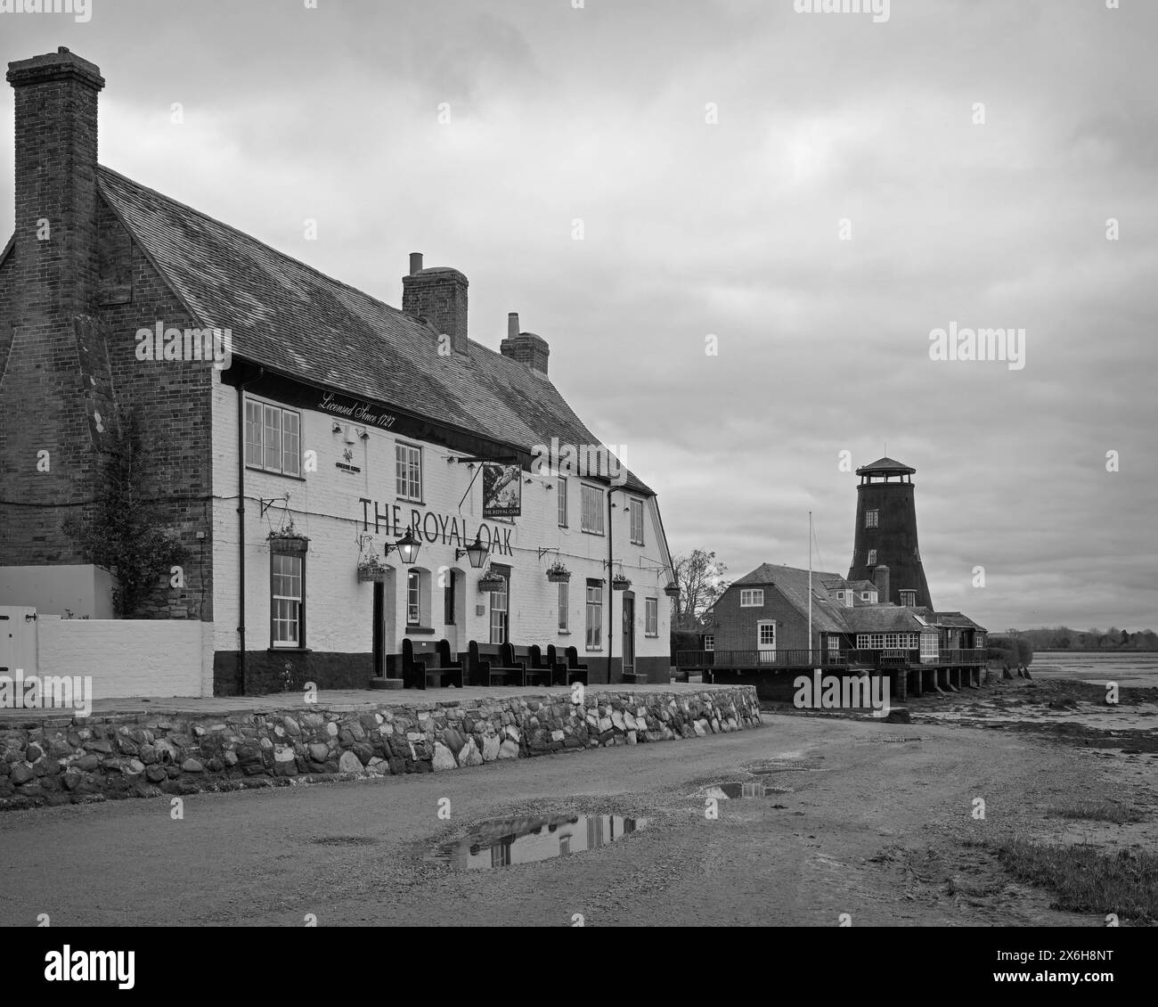 Schwarz-weiß-Bild des Royal Oak Publishauses und der Langstone Mill an der Küste auf der Spitze des Langstone Harbour, Havant, Hants, England, Großbritannien Stockfoto