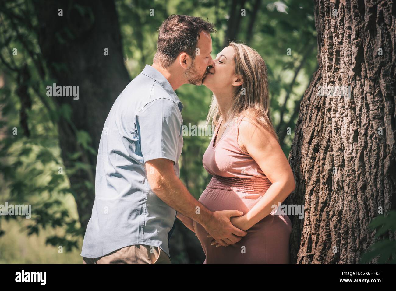Familie im Sommerpark zusammen. Frau ist schwanger Stockfoto
