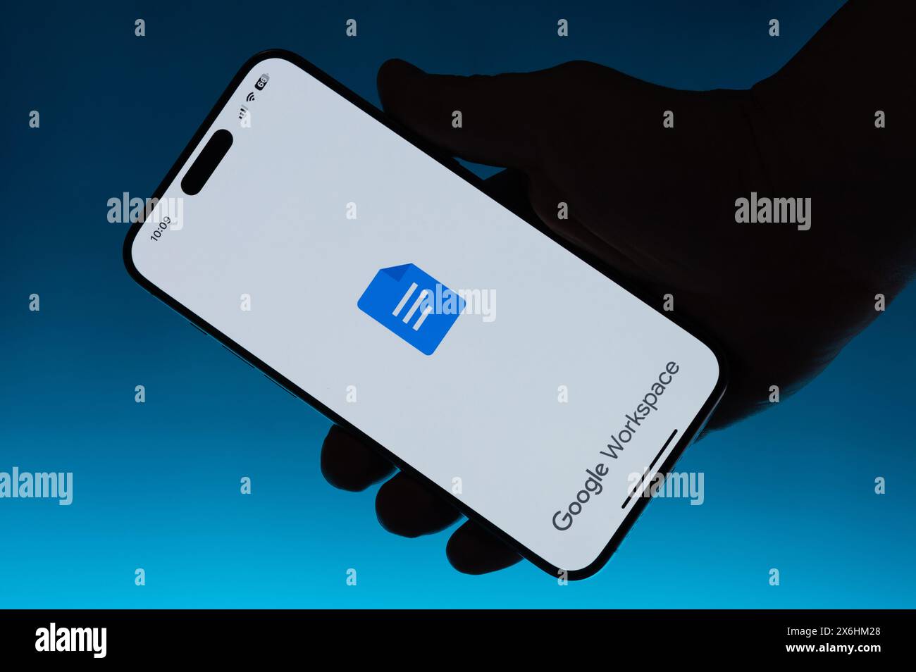 New York, USA - 6. Mai 2024: Verwendung der Google Workspace App auf Smartphone in Hand isolierter blauer Hintergrund Stockfoto