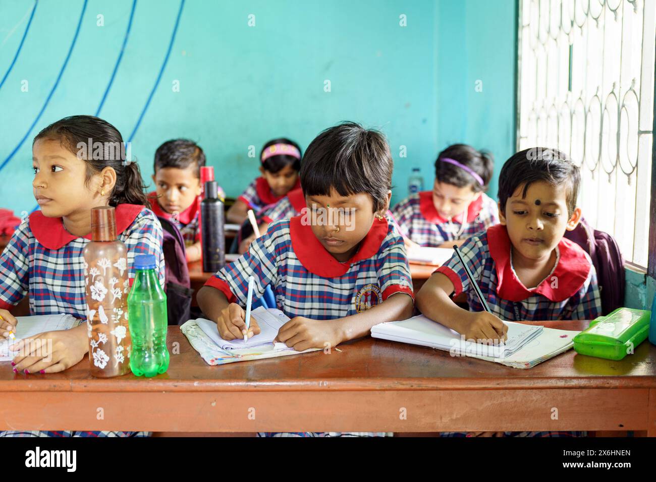 Kalkutta, Indien - 20. Oktober 2024: Kinder in Uniform schreiben und Notizen in einer indischen Schule machen. Konzept von Wachstum, Bildung, Inspiration und Chil Stockfoto