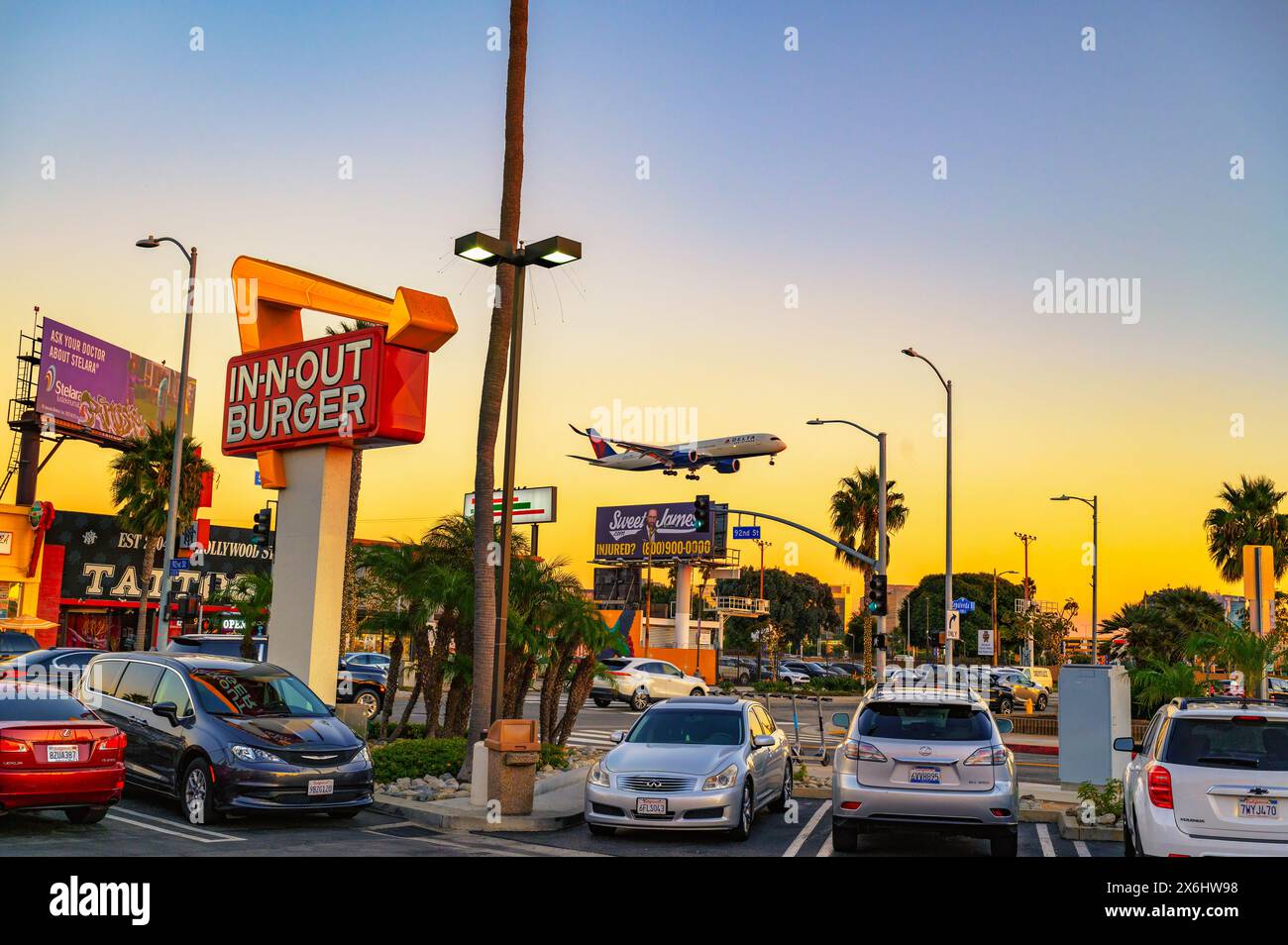 In-N-Out Burger Restaurant mit Landungsflugzeug bei Sonnenuntergang in Los Angeles Stockfoto
