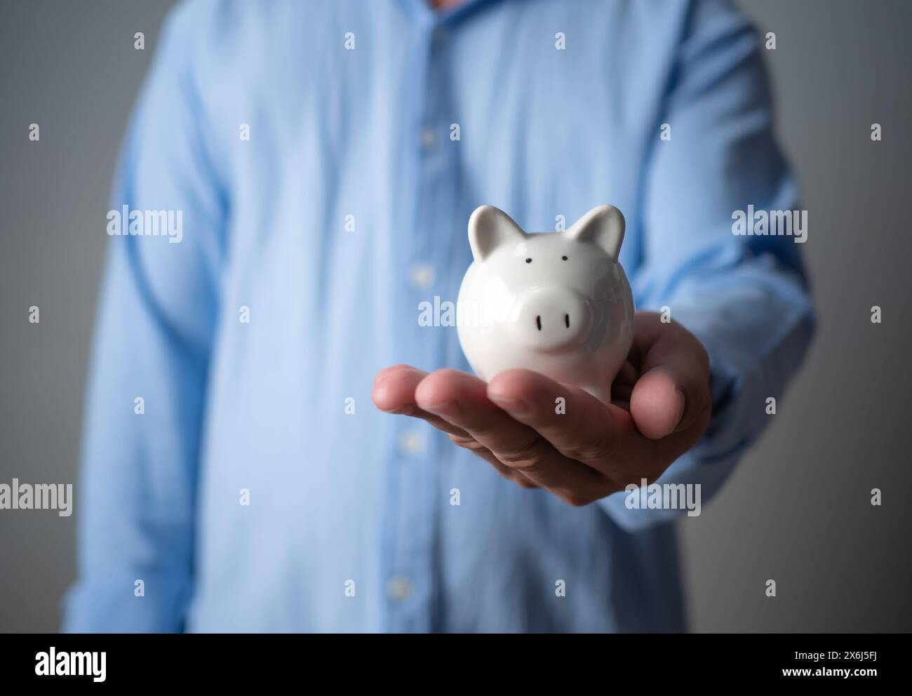 Geld sparendes Konzept. Geschäftsmann, der die weiße Sparkasse hält. Außer für Investitionen, Bankgeschäfte, Darlehen, Wohnungsdarlehen, Finanzplan Stockfoto