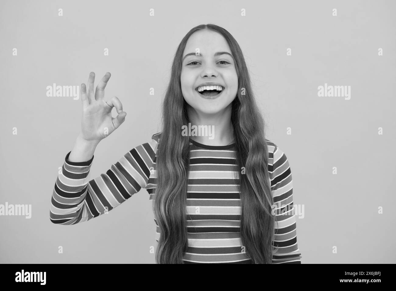 Okay. Portrait von teen Mädchen machen ok Geste, isoliert Hintergrund. Junger Teenager lächelte und gab Okey Zeichen. Glücklich niedliches Kind zeigt okay. Stockfoto