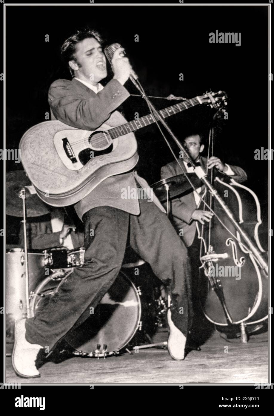 Elvis Presley 1950s Florida Bühnenauftritt mit seiner Gitarre, hielt das Mikrofon, während er in voller Strömung kreiste und spielte Rock & Roll auf der Bühne, mit seiner Gitarre zu Beginn seiner Karriere 1956 Florida USA Stockfoto