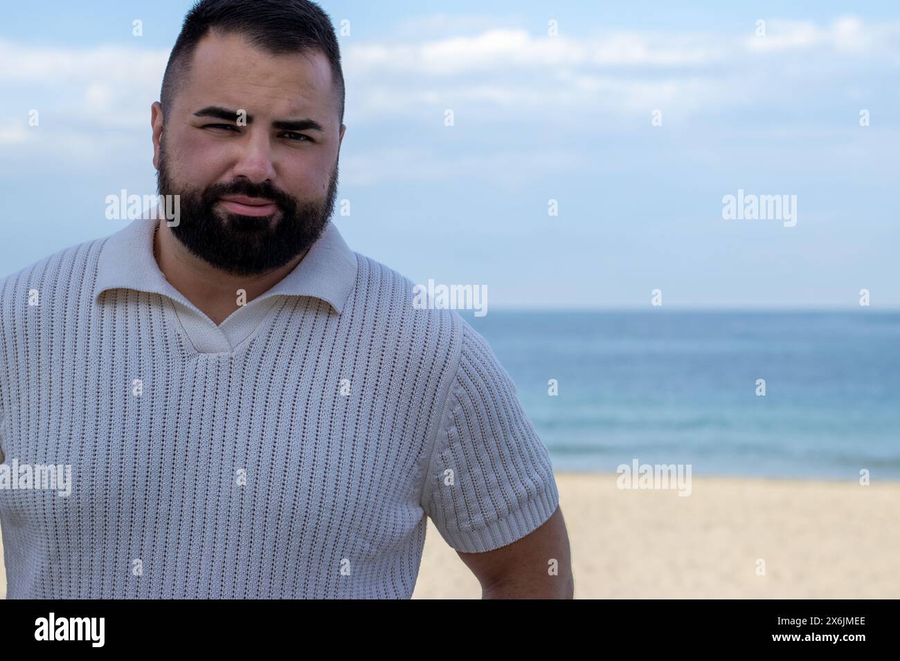 Das Bild fängt einen 30-jährigen Mann in einem Moment der ruhigen Besinnung am Meer ein. Stockfoto