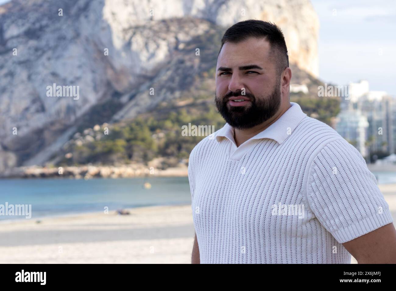 Das Bild zeigt einen 30-jährigen Mann vor der atemberaubenden Kulisse von Calpes Ifach Rock. Stockfoto