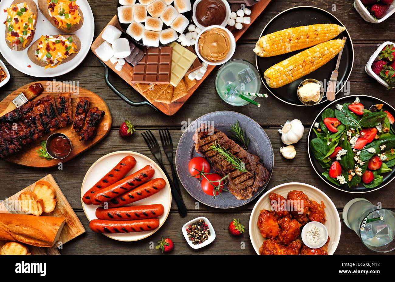 Sommer-Grilltisch-Szene auf weißem Holzbanner Hintergrund. Auswahl an gegrilltem Fleisch, Gemüsegerichten und Smores-Platte. Draufsicht. Stockfoto