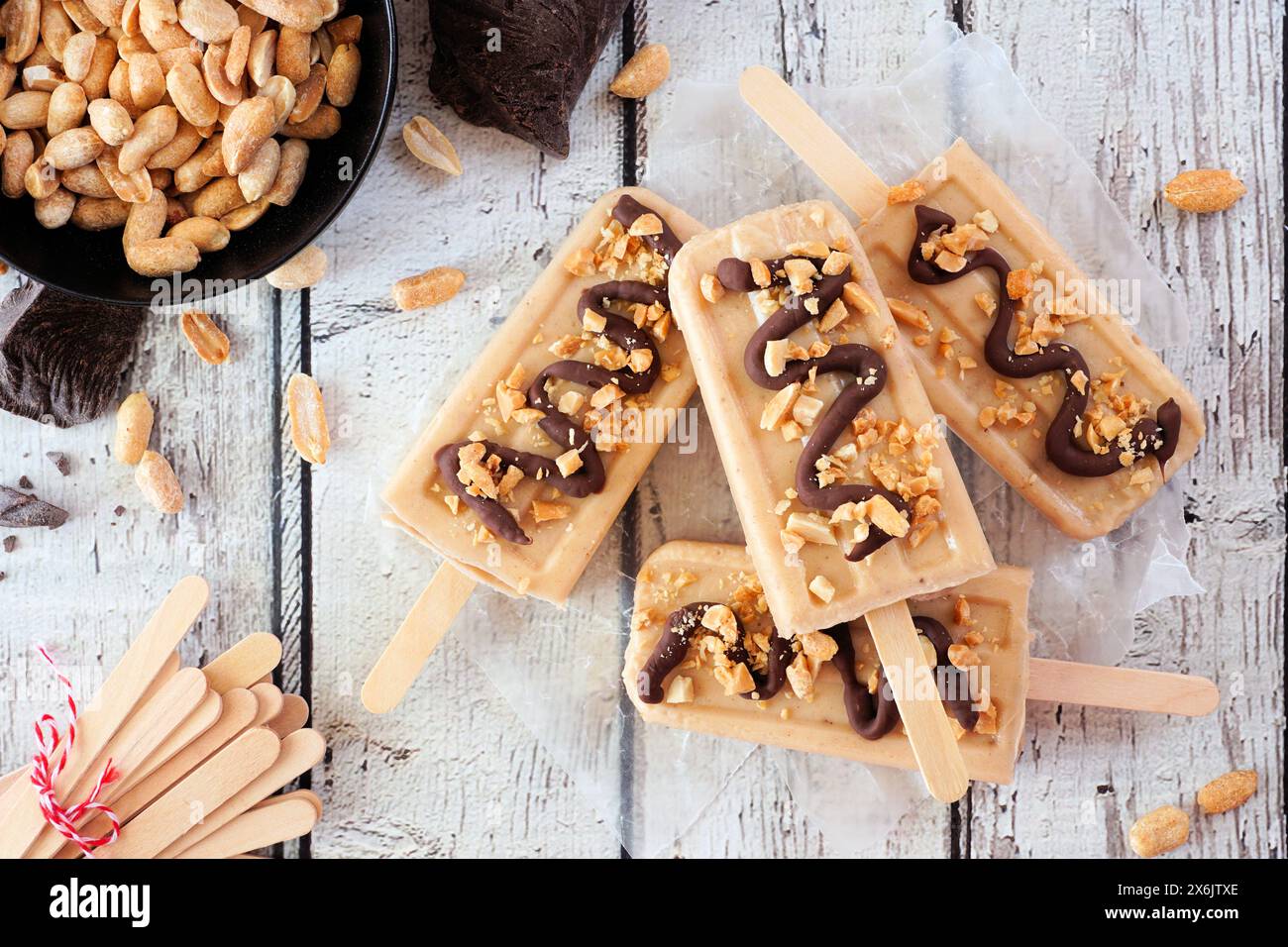 Erdnussbutter-Eis mit Schokoladengriß. Oben sehen Sie die Tischszene über einem weißen Holzhintergrund. Stockfoto