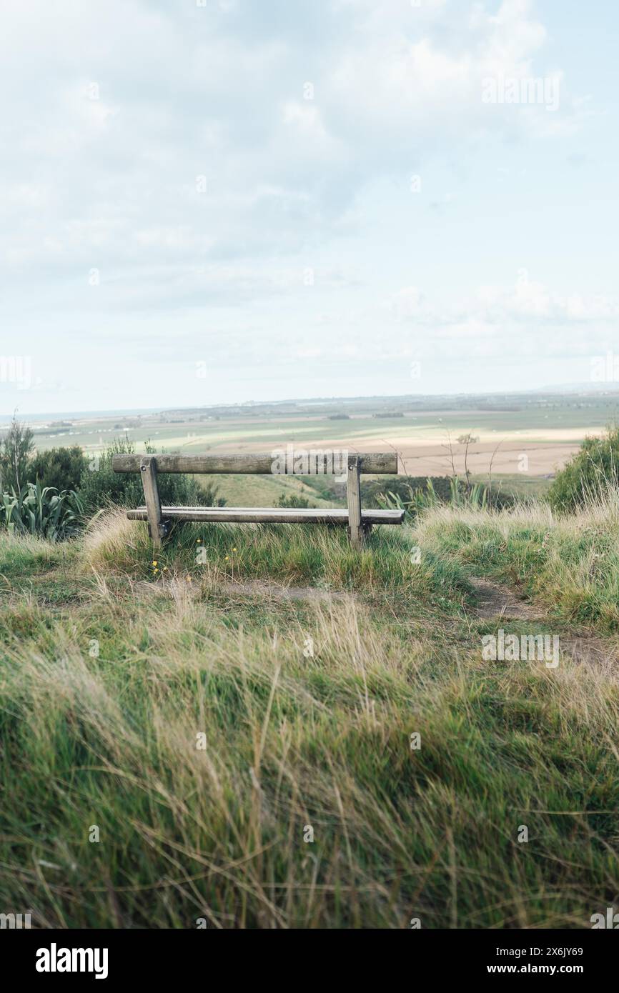 Holzzaun vor einer offenen Landschaft mit großem Himmel und Grasfeld Stockfoto