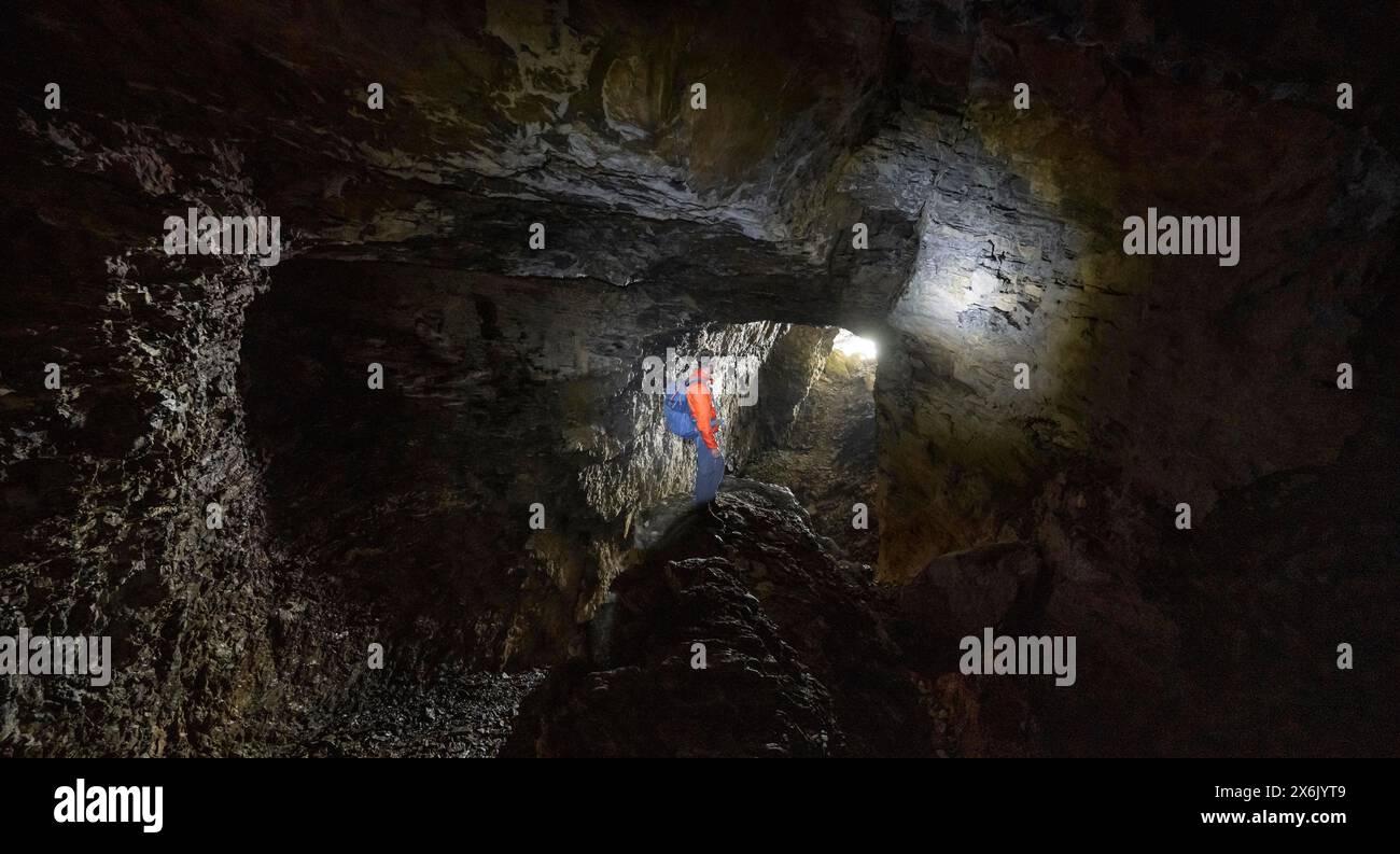 Wanderer erkunden die Obstans Eishöhle im Hochpustertal, Karnischen Alpen, Osttirol, Österreich Stockfoto