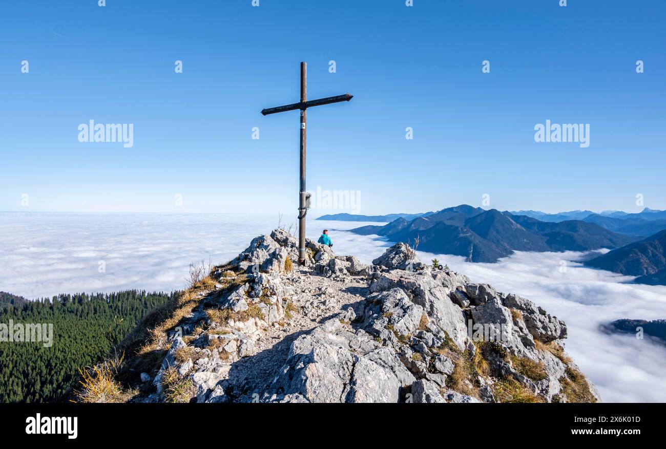 Gipfelkreuz am Ettaler Manndl, Blick über Berglandschaft und Wolkenmeer, Hochnebel im Tal, Ammergauer Alpen, Bayern, Deutschland Stockfoto