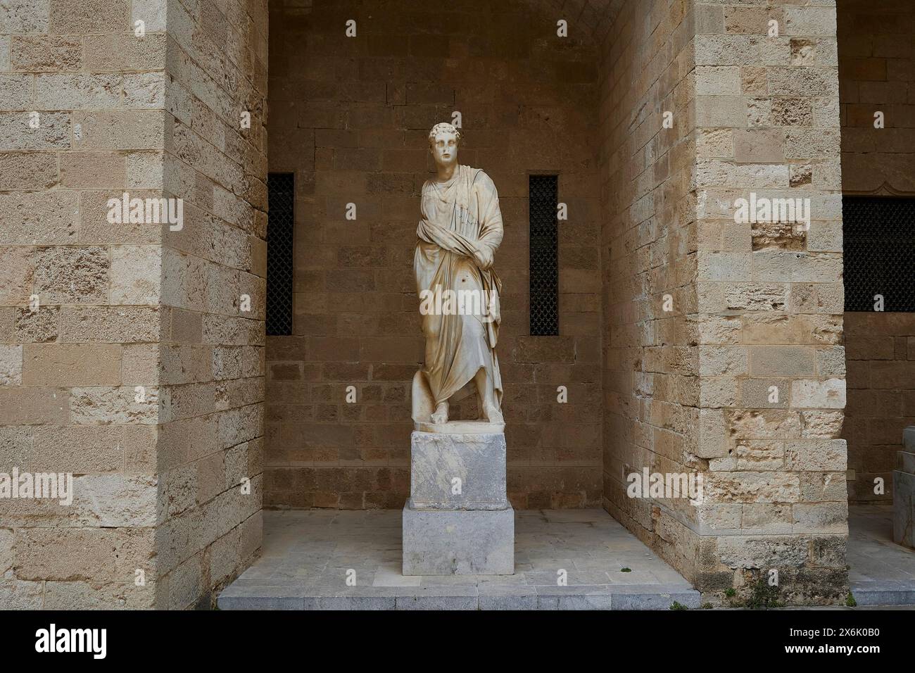 Statue einer stehenden Figur in antikem Kleid in einer Sandsteinnische, Statue aus dem 2. Jahrhundert v. Chr., Innenhof, Palast des Großmeisters, Ritterstadt, Rhodos Stockfoto