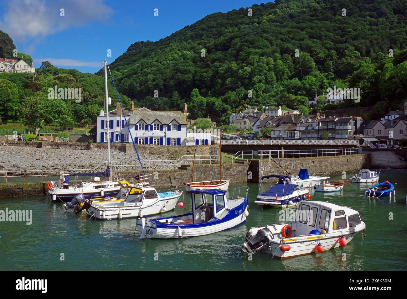 Kleiner Hafen, Fischerboote und ein kleines Dorf in einer hügeligen Landschaft, North Devon. Großbritannien Stockfoto